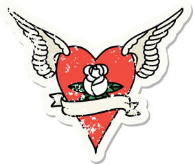 traditional distressed sticker tattoo of a flying heart with flowers and banner