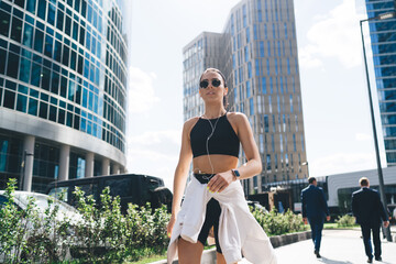 Modern slim sportswoman walking in business center