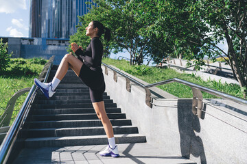 Sportswoman clasping hands and stretching leg