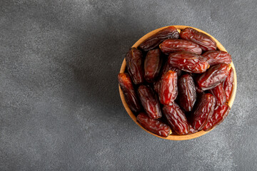 Date fruits in wooden bowl,on black background 