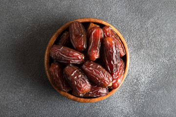 Date fruits in wooden bowl,on black background 