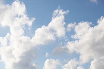 Naklejka na ściany i meble Blue sky with white fluffy clouds in sunny weather.
