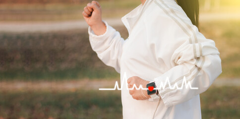 Fitness woman with heart rate monitor running on park with running training during morning workout,female checking heartrate and pulse from smart watch monitor running healthy lifestyle concept.