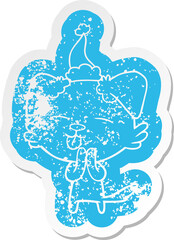 cartoon distressed sticker of a dog sticking out tongue wearing santa hat
