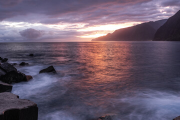 Beautiful sunrise over Madeira Seixal beach. Cliffs and rocks and atlantic ocean waces at long exposure