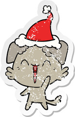 happy little dog distressed sticker cartoon of a wearing santa hat