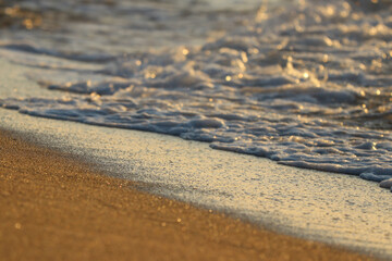 Detalles de la orilla del mar al amanecer y espuma de mar