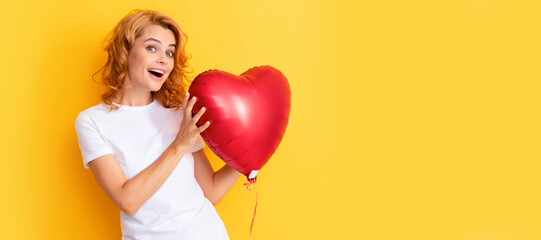 amazed happy redhead girl with love heart balloon. charity and donation. Beautiful woman isolated face portrait, banner with mock up copy space.