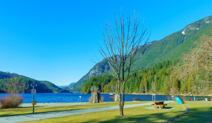 Lonely beach on a bright, sunny day at Buntzen Lake park, Anmore, BC, at the cusp of Spring.