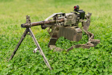 Automatic firearms. Machine gun weapon on green grass closeup.