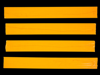 4 horizontal pieces of orange masking tape isolated on a black