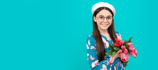 smiling child in beret with tulips. mothers or womens day. kid in glasses hold flowers. Banner of spring child girl with tulips flowers bouquet, studio portrait with copy space.