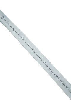 Close-up shot of a twilly ribbon for hair. Women's silk hair band with letter pattern is isolated on a white background. Front view.