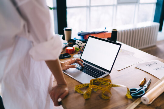 Anonymous woman using laptop at workplace