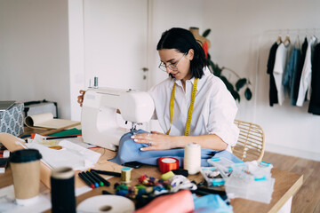 Focused female tailor working in atelier