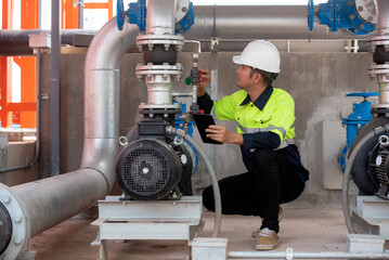 Fototapeta na wymiar Engineer with tablet check red generator pump for water sprinkler piping and fire alarm control system.