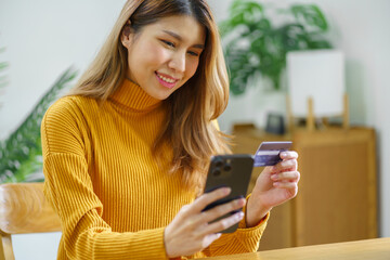 Fototapeta premium Woman shopping&nbsp;on laptop holding credit card for Internet online e-commerce shopping spending money Online shopping Mobile phone laptop technology concept
