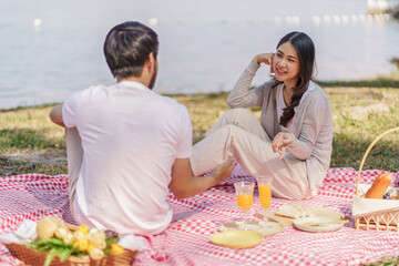  In love asian couple enjoying picnic time in park outdoors Picnic. happy couple relaxing together with picnic Basket