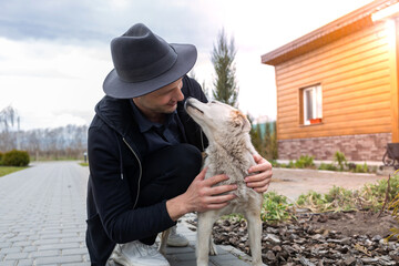 Cropped image of handsome young man with his dog outdoors. 