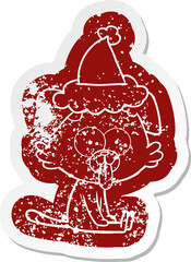cartoon distressed sticker of a sitting dog with tongue sticking out wearing santa hat