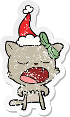 distressed sticker cartoon of a cat meowing wearing santa hat