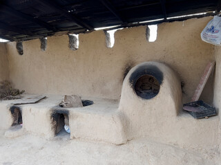 The clay oven and two cauldron stands for cooking.