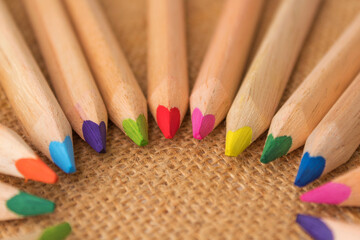 Multicolored crayons in a row on a natural background