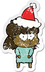 distressed sticker cartoon of a whistling girl wearing santa hat