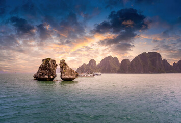 View of Hon Ga Choi Island or Cock and Hen, Fighting Cocks Island located in Ha Long bay, Vietnam, Trong Mai island, junk boat cruise and boats, popular landmark