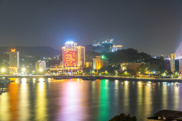 Fototapeta na wymiar Colorful night view of Bai Chay Bridge, connecting two parts of Ha Long City, Hon Gai City and Bai Chay City through Cua Luc Bay.