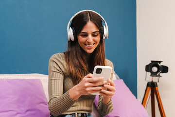 Portrait of one young happy caucasian woman having fun listening music using a smartphone app on...