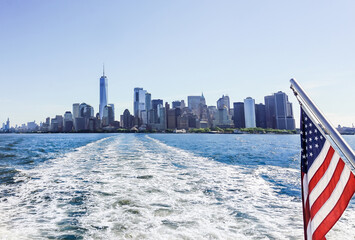 Scenic New York City ferry travel. NY skyline and landscape. Flag of the USA. Buildings, water and...