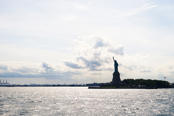 New York and storm clouds on sky. Statue of Liberty before or after bad weather. Problems coming to USA concept. Ominous, dark and dramatic NY. Silhouette of landmark. © terovesalainen