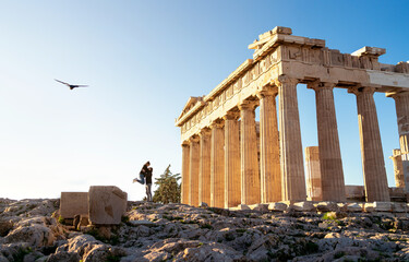 Greece, Athens. Tourist couple at Acropolis. Two people at Parthenon ruins. Travel and tourism. Woman and man on romantic date, city vacation or honeymoon. Ancient temple sightseeing at sunset.