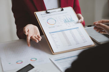 Two businessmen are brainstorming together and reviewing the company financial documents that the finance department has summarized, they are business partners. Business administration concept.