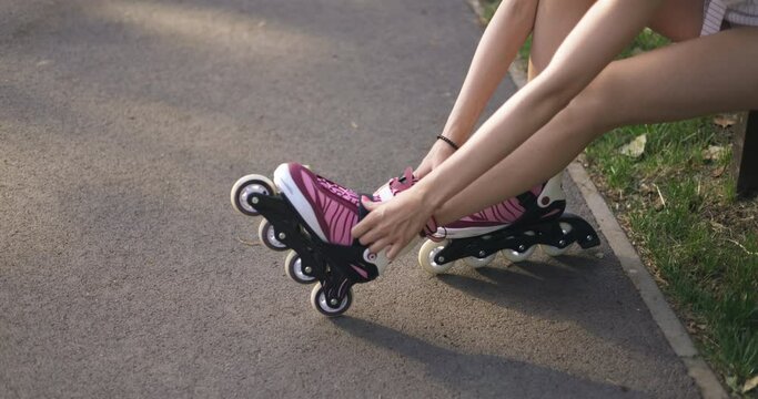 Profile of the legs of a girl sitting on a bench wearing rollerblades