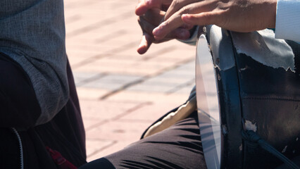 A Gipsy street musician plays the tambourine or Turkish drum Darbuka with fast rhythms on the...