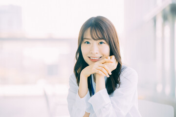 肘をつく笑顔の日本人女性ビジネスマン