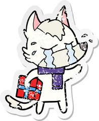 distressed sticker of a cartoon crying wolf with christmas present