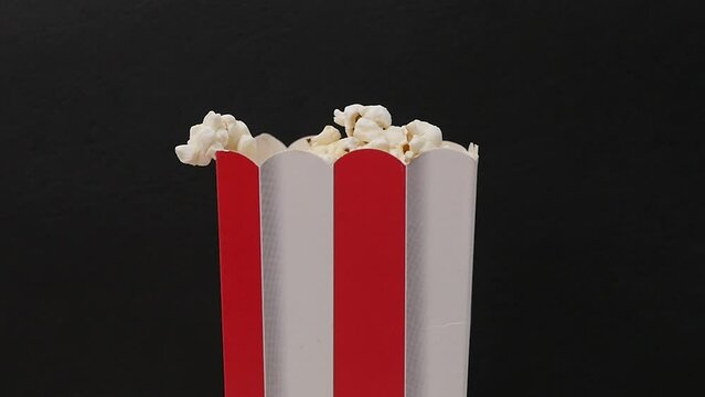 Filling red white paper box with fresh popcorn, food for watching movies, going out for fun, time to rest, entertainment, films, cinema. Close up, 4K Ultra HD.