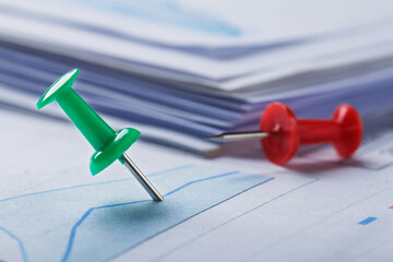Marking financial chart by pins.Share listing and checking financial chart. Concept of banking, financial report and financial audit.