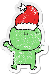 distressed sticker of a cute cartoon frog wearing christmas hat