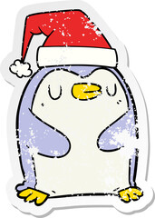 distressed sticker of a cartoon penguin wearing christmas hat