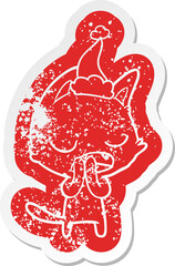 talking cat cartoon distressed sticker of a wearing santa hat