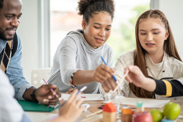 Diversity group of students drawing and painting in Arts class with African American teacher. kid enjoy practicing art skill, creative thinking idea. school activity, learning and education concept	