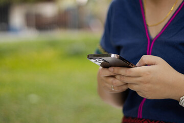 woman playing with smartphone in the park