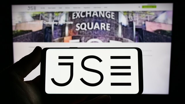 Stuttgart, Germany - 03-25-2023: Person holding smartphone with logo of JSE Limited (Johannesburg Stock Exchange) on screen in front of website. Focus on phone display.