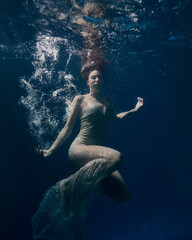 beautiful young girl under water in a long white dress with long hair the magic of the sea