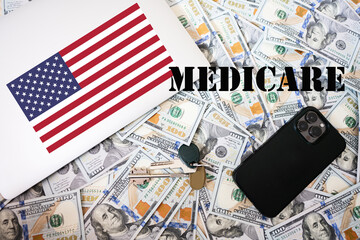 Medicare concept. USA flag, dollar money with keys, laptop and phone background.