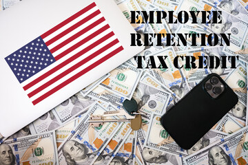 Employee retention tax credit concept. USA flag, dollar money with keys, laptop and phone...